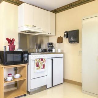 A compact kitchen setup featuring a refrigerator, microwave, and coffee maker.
