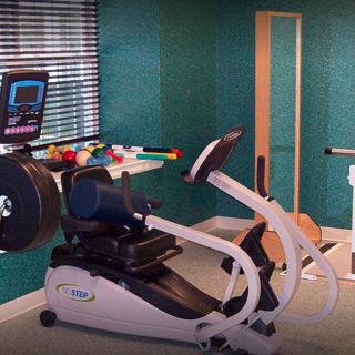 A well-equipped home gym featuring a stationary bike and other exercise equipment.