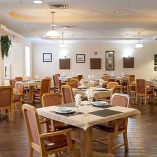 A spacious and well-lit dining area with neatly arranged tables and chairs.