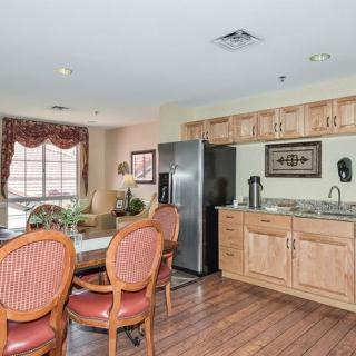 A cozy kitchen and dining area with wooden cabinets and a table surrounded by chairs.