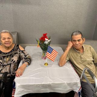 An elderly couple enjoying a moment together at a decorated table.