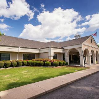 A picturesque building with an arched entrance, set against a backdrop of blue sky and clouds.