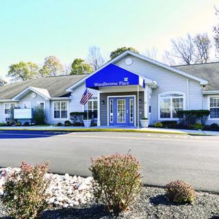 A healthcare clinic building with a blue sign and well-maintained landscaping.
