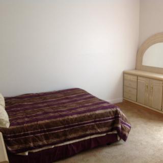 A minimalist bedroom with a bed and a dresser.