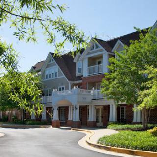 A scenic view of a residential building surrounded by greenery on a sunny day.