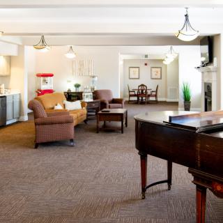 Spacious living area with comfortable seating and a piano.