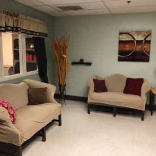 A cozy waiting room featuring comfortable sofas and decorative elements for a welcoming atmosphere.
