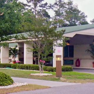 A building with a covered entrance and landscaped surroundings.