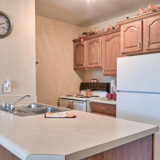 A cozy kitchen with wooden cabinets and a white refrigerator.