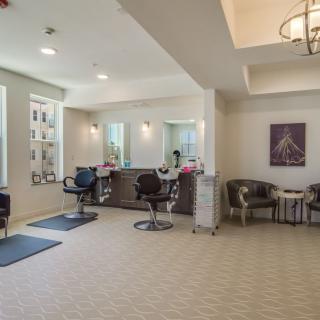 Modern salon interior with styling chairs and a cozy waiting area.