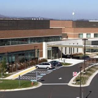A modern healthcare facility with an entrance and parking area.