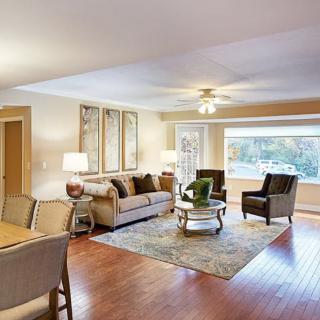 A cozy living room with modern furnishings and a large window overlooking greenery.