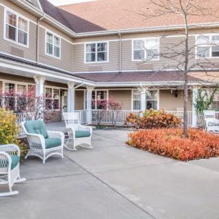 A cozy courtyard with seating and autumn foliage outside a residential building.