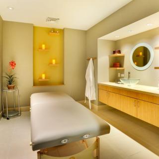 A serene massage room with ambient lighting and a comfortable massage table.