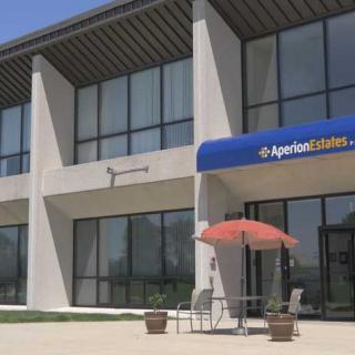 A real estate office with a modern design and outdoor seating area.