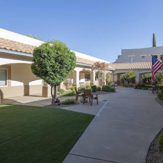 A serene courtyard featuring well-maintained landscaping and an American flag.