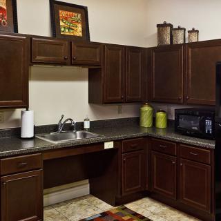 A modern kitchen with dark wood cabinets and sleek countertops.