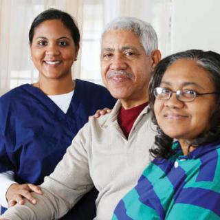 A nurse with senior patients smiling together.