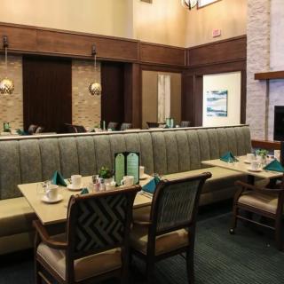 An empty restaurant interior featuring booth seating and neatly set tables.