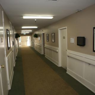 A well-lit corridor with doors and wall decorations.
