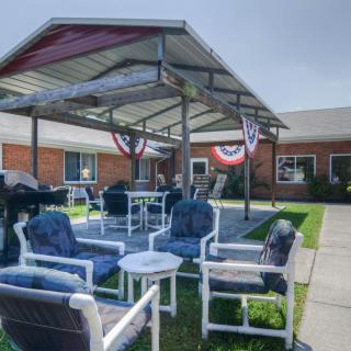 A courtyard with a covered patio area featuring chairs and tables.