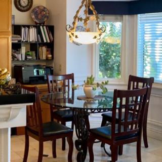 A cozy kitchen dining area with a round table, wooden chairs, and a decorative chandelier.