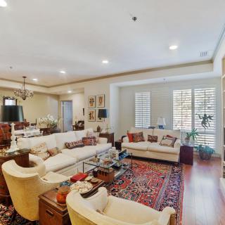 A spacious and elegantly decorated living room with comfortable seating and a patterned carpet.