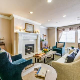 A cozy and elegantly designed living room featuring a fireplace, comfortable seating, and tasteful decor.