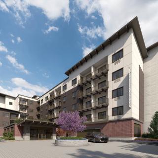 A modern hotel building with a stylish architectural design under a partly cloudy sky.
