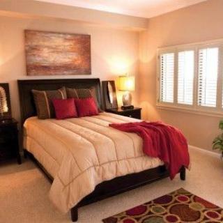 A cozy bedroom with a neatly made bed, warm lighting, and elegant decor.