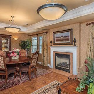 A cozy dining room featuring elegant furniture and a warm fireplace.