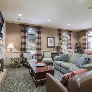 A cozy living room with a comfortable sofa and coffee table, complemented by large windows and stylish decor.