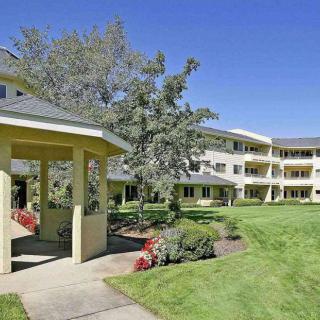 An apartment complex with a well-maintained lawn and pathways.