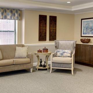 A cozy living room with a sofa, armchair, and decorative elements.