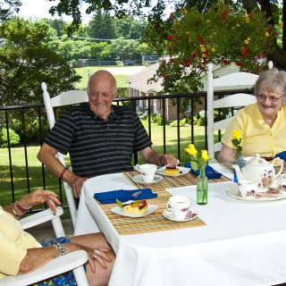 A group of seniors enjoying an outdoor teatime gathering.