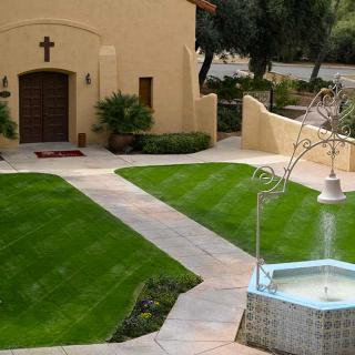 A serene church garden featuring a fountain and well-maintained pathways.