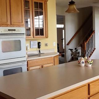A cozy kitchen with a built-in oven and wooden cabinets.