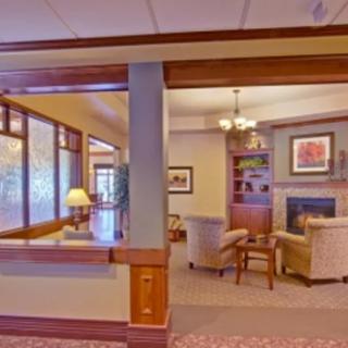 A cozy lobby interior featuring a seating area with a fireplace and comfortable chairs.