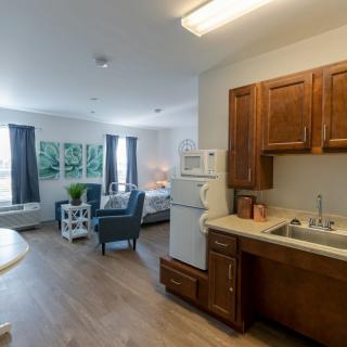 A cozy apartment interior featuring a compact kitchen and a comfortable living area.