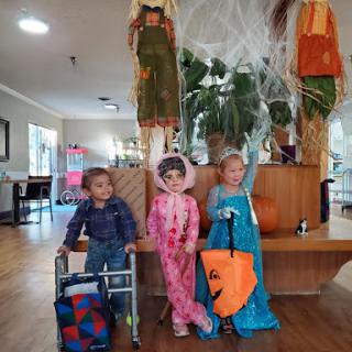A fun Halloween celebration with children dressed in colorful costumes, surrounded by festive decorations.