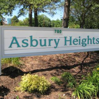 Entrance sign for Asbury Heights, surrounded by greenery.