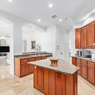 A modern kitchen featuring elegant wooden cabinets and a spacious granite island.