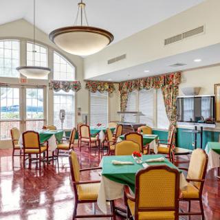 A spacious and elegantly designed dining area featuring tables and chairs, bathed in natural light.