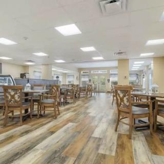 An empty restaurant dining area with wooden flooring and seating.