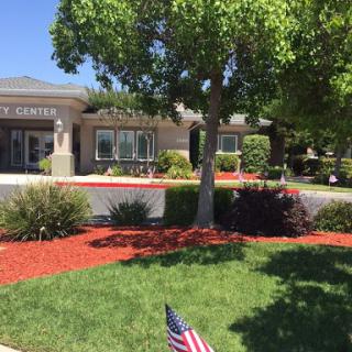 A well-maintained community center surrounded by lush greenery and vibrant landscaping.