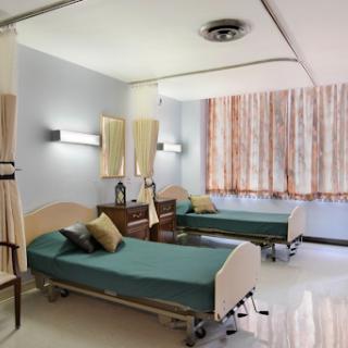 A well-lit hospital patient room featuring twin beds and modern decor.