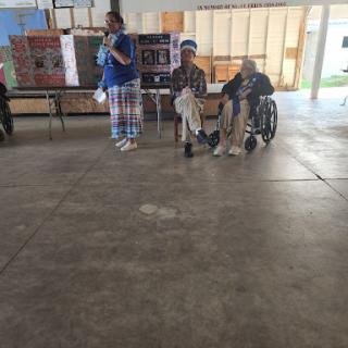 A community event featuring a presentation, where individuals are engaged in conversation.