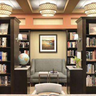 A cozy library corner with shelves full of books, a comfortable sofa, and a globe.