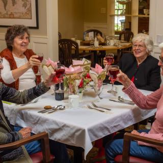 A group of seniors enjoying a meal together, raising glasses in celebration.