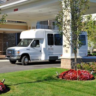 A white van parked in front of a building with well-maintained landscaping.